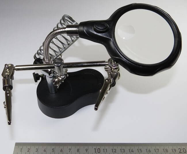 Helfende Hand mit Lupe. Stabiler Stand-  Fuss aus